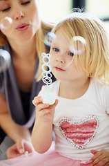 Image showing Blow, bubbles and games with mom and child together in home playing with toys for fun. Playful, mother and girl with liquid, soap and bonding on holiday, vacation or relax on weekend with love