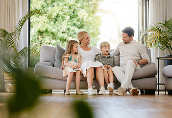 Image showing Smile, happy and children with parents on a sofa relaxing in the living room of modern house. Bonding, love and young kids relaxing, resting and sitting with mother and father in the lounge at home.