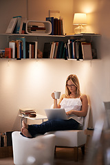 Image showing Woman, laptop and reading with coffee at night on chair in relax or living room at home. Female person, journalist or bookworm sitting with cup of tea and computer for online connection at house