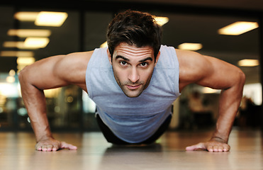 Image showing Portrait, man and fitness with push up in gym for exercise in strength, health or wellness. Male person, alone and training on floor with workout routine for endurance, concentration and dedication