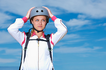 Image showing Woman, skydiver and helmet in outdoors, adventure and recreation or extreme sports for fun or equipment. Female person, travel and outside or fitness, holiday and vacation or getaway by blue sky
