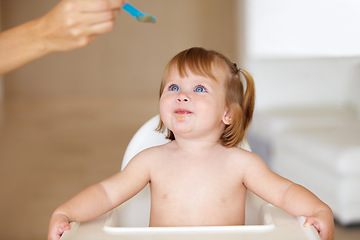 Image showing Family, growth and a parent feeding her baby breakfast in the morning while in a home together for development. Children, food and a girl toddler eating with a healthy meal in an apartment kitchen