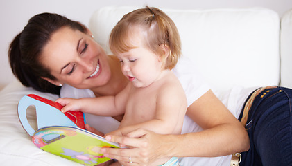 Image showing Baby, mother and book or reading on sofa with learning, relax and parenting in living room of home with smile. Family, woman and girl child with happiness on couch in lounge for development and love