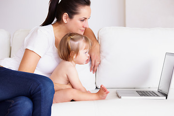Image showing Family, laptop or streaming with a mom and baby on a sofa in the living room of a home for entertainment. Computer, movie or childcare with a woman parent and toddler girl in an apartment together