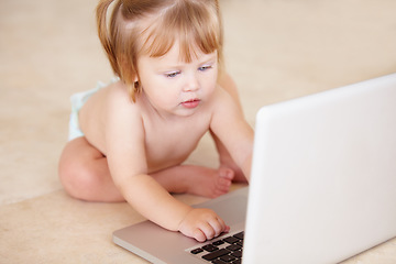 Image showing Growth, learning and a baby typing on a laptop on the floor of a living room in her home for child development. Kids, computer and internet with an adorable infant girl alone in her apartment