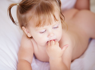 Image showing Face, growth and child development with a baby in the bedroom to relax alone in the morning. Home, kids or youth and an adorable young infant girl on a bed with blankets for comfort in an apartment