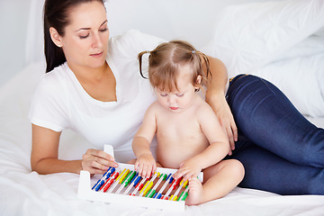 Image showing Family, learning or abacus with a mother and baby on a bed in their apartment together for child development. Growth, education or math and an infant girl counting with her parent in a home bedroom