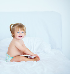 Image showing Smile, learning and a baby with a book in the bedroom of a home for growth or child development. Kids, storytelling or reading with a happy young infant girl sitting on a bed in an apartment