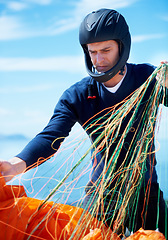 Image showing Paragliding, parachute or man with strings in nature in preparation, exercise or health support. Young person, fitness or wellness for outdoor with safety harness, helmet or adventure in countryside