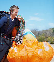 Image showing Paragliding, parachute or man in nature with equipment, preparation or helmet to exercise for health. Athlete, extreme and sports with fitness for outdoor wellness, backpack and happy in countryside