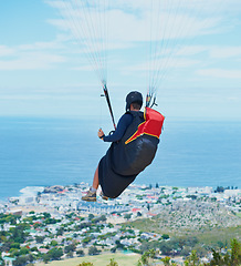 Image showing Man, parachute or paragliding in blue sky for ocean view, flight freedom or adventure in extreme sport. Pilot, nature and fearless in outdoor fitness for health, sports and wellness with glide in air