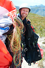 Image showing Paragliding, parachute or man in nature for portrait, happy or strings for training for flight preparation. Athlete, face or smile for fitness for outdoor wellness, helmet or equipment in countryside