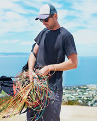 Image showing Man, parachute or safety in nature for sport, preparation or harness to exercise for health. Athlete, extreme sports or strings for fitness with outdoor wellness, equipment and gear for paragliding