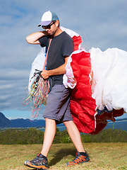 Image showing Equipment, parachute or man in nature for sport, smile or strings for exercise for health support. Person, walk or preparation in outdoor fitness for wellness, fearless or safety gear in countryside