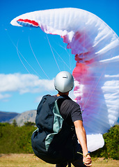 Image showing Man, parachute and launch sport with courage, healthy adventure and paragliding for extreme fitness. Person, preparation and fearless in forest for flight take off with helmet and safety gear in wind