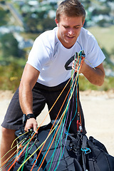 Image showing Man, safety harness or paragliding sport in launch in training, healthy adventure or extreme fitness. Person, preparation and fearless outdoor for flight with smile and parachute gear in countryside