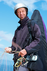 Image showing Paragliding, parachute and man with portrait in nature in preparation, exercise or health support. Athlete, face or fitness for happy outdoor with safety harness, helmet or equipment in countryside