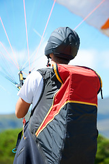 Image showing Man, parachute or paragliding launch in nature, exercise or healthy adventure for extreme sport. Person, strings or training for outdoor fitness for wellness, helmet or safety gear by blue sky