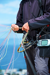 Image showing Paragliding, rope and sport with hands of person in nature for flight, travel or vacation. Safety gear, holiday and trip with closeup of man and strings in outdoors for action, parasailing and cord