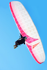 Image showing Person, parachute or paragliding in air in nature, exercise or healthy adventure for extreme sport. Athlete, glide and fearless for outdoor fitness for wellness, below and safety gear by blue sky