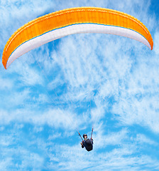 Image showing Man, paragliding and blue sky adventure in clouds for explore city, outdoor courage or fearless athlete. Male person, parachute and air wind fun or safety equipment for landing, flying fit in nature