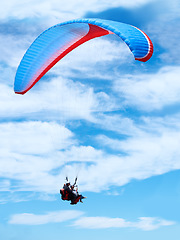 Image showing Man, parachute or paragliding in blue sky for adventure, flight freedom or courage with extreme sport. Pilot, nature and fearless in outdoor fitness for health, sports and wellness with glide in air