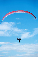 Image showing Person, parachute and paragliding in blue sky in air, nature for exercise with healthy adventure for extreme sport. Athlete, flight or fearless by outdoor fitness for wellness, helmet or safety gear