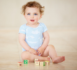 Image showing Baby, boy and blocks for building, floor and smile with development, learning or playful in family home. Infant child, toys and education for progress, growth or childhood with sitting, room or house