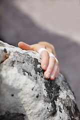 Image showing Person, grip and rock climbing or finger tape on hand for exercise injury, sports pain on nature cliff. Athlete, boulder and hanging for explore peak practice for brave adventure, risk on mountain