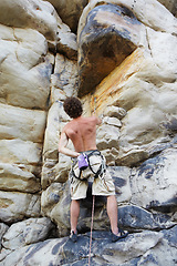 Image showing Man, rock climbing and rope on mountain or chalk bag for cliff grip, adventure holiday as athlete. Male person, exercise and challenge gear as cardio fearless, active discipline for extreme sports