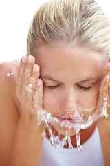 Image showing Skincare, washing and face of woman with water in studio for hygiene, wellness and facial treatment. Spa, dermatology and person with liquid splash for cleaning, beauty and health on white background