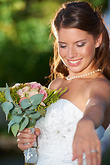 Image showing Happy woman, bride and bouquet of flowers at wedding for marriage, love or commitment at outdoor ceremony. Married female person smile with floral roses in beauty or dress for celebration in nature