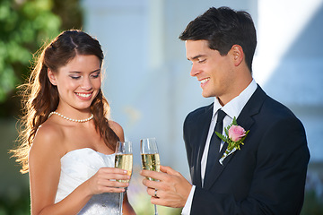 Image showing Happy couple, wedding and champagne glasses in celebration for marriage, love or commitment at outdoor ceremony. Married man and woman smile with alcohol for toast, date or cheers on honeymoon