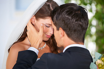 Image showing Married couple, kiss and love at wedding for affection, marriage or romance together at outdoor ceremony. Man and woman in care, embrace or compassion for commitment, trust or loyalty in nature