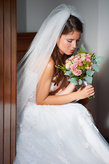 Image showing Bride, woman and smelling a bouquet at wedding, ceremony or event for aroma, scent and happy in dress. Marriage, person and flowers or roses for commitment, love and new beginning with smile or joy