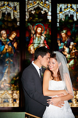 Image showing Happy couple, hug and kiss at wedding in church for marriage love or vow in commitment together. Married man or groom hugging woman or bride smile for embrace, loyalty or support in trust at ceremony