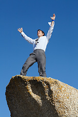 Image showing Businessman, success and freedom on cliff with sky, rock and peak of mountain in nature. Happy, person and celebration of winning an achievement, challenge or climbing in business and career progress