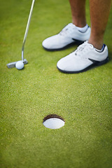 Image showing Sports, golf hole and shoes of golfer on course playing game, practice and training for competition. Recreation, grass and closeup of person by tee, ball and golfing club for winning stroke or score