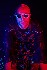 Image showing authentic triathlete swimmer having a break during hard training on night neon gel light