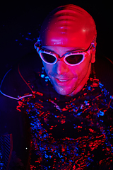 Image showing authentic triathlete swimmer having a break during hard training on night neon gel light