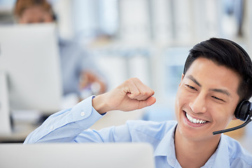 Image showing Man, telemarketing and phone call celebrate happy for customer service, office work or company sale. Asian person, fist for achievement as communication employee for care, discussion at help desk