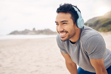 Image showing Break, beach and man workout to relax with a smile after cardio exercise. Fitness, jog and healthy athlete or male person rest in natural ocean with headphones for music and physical wellness