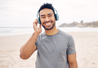 Image showing Smile, headphones and portrait of man on the beach running for race, marathon or competition training. Happy, fitness and young male athlete listen to music, radio or playlist for exercise by ocean.