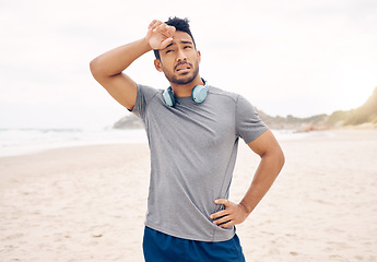 Image showing Tired, fitness and man on a beach taking a break after workout for active lifestyle. Exercise, natural ocean and male person with fatigue or exhausted after training run and wiping sweat after jog