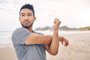 Image showing Fitness, stretching and a young man on the beach at the start of his workout for health or wellness. Exercise, thinking and warm up with a confident athlete training outdoor by the ocean or sea