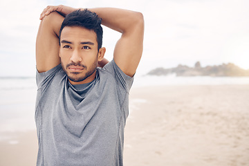 Image showing Exercise, stretching and a young man on the beach at the start of his workout for health or wellness. Fitness, thinking and warm up with a confident young athlete training outdoor by the ocean or sea