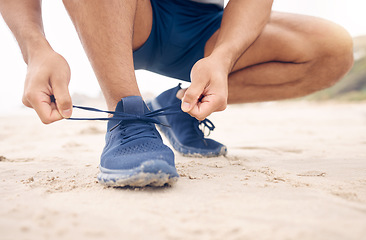 Image showing Running shoes, hands and fitness man at a beach for training, exercise or morning cardio zoom. Legs, closeup and male runner with sneakers lace outdoor for wellness, workout or marathon practice run