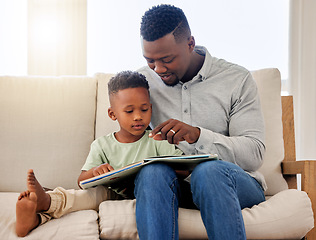 Image showing African, child and father reading a book in home on sofa with development of education, learning and knowledge. Happy dad, teaching and show kid a story in books and relax in living room on couch