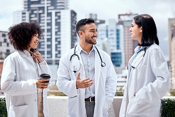Image showing Happy, doctors and talking of healthcare on coffee break, outdoor and relax at hospital, clinic or colleagues on rooftop. Surgeon, smile and enjoy drink on balcony with staff and work in medicine