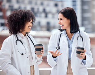 Image showing Conversation, coffee and young women doctors talking on medical diagnosis on hospital rooftop. Smile, discussion and female healthcare workers speaking and drinking cappuccino on clinic balcony.